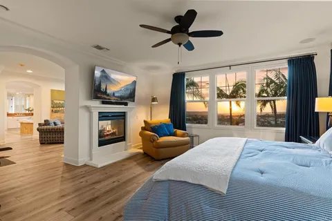 a large bedroom with furniture a fireplace and a flat screen tv