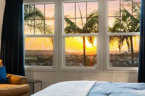 a living room with a large window and a bed
