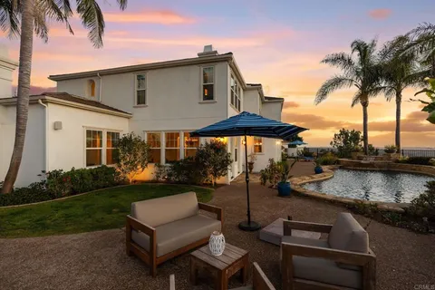 a backyard of a house with yard table and chairs