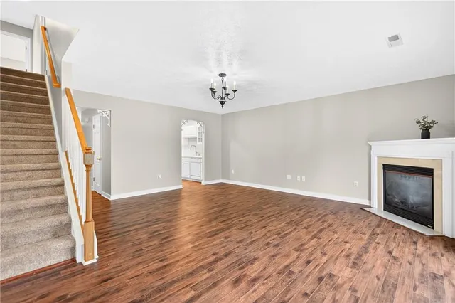 a view of an empty room with window and wooden floor
