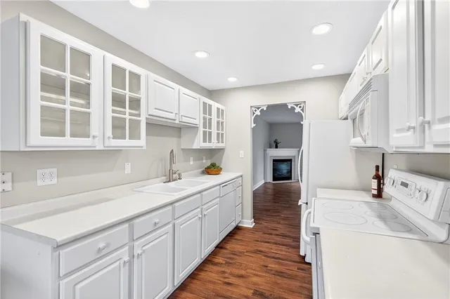 a kitchen that has a lot of white cabinets and wooden floor