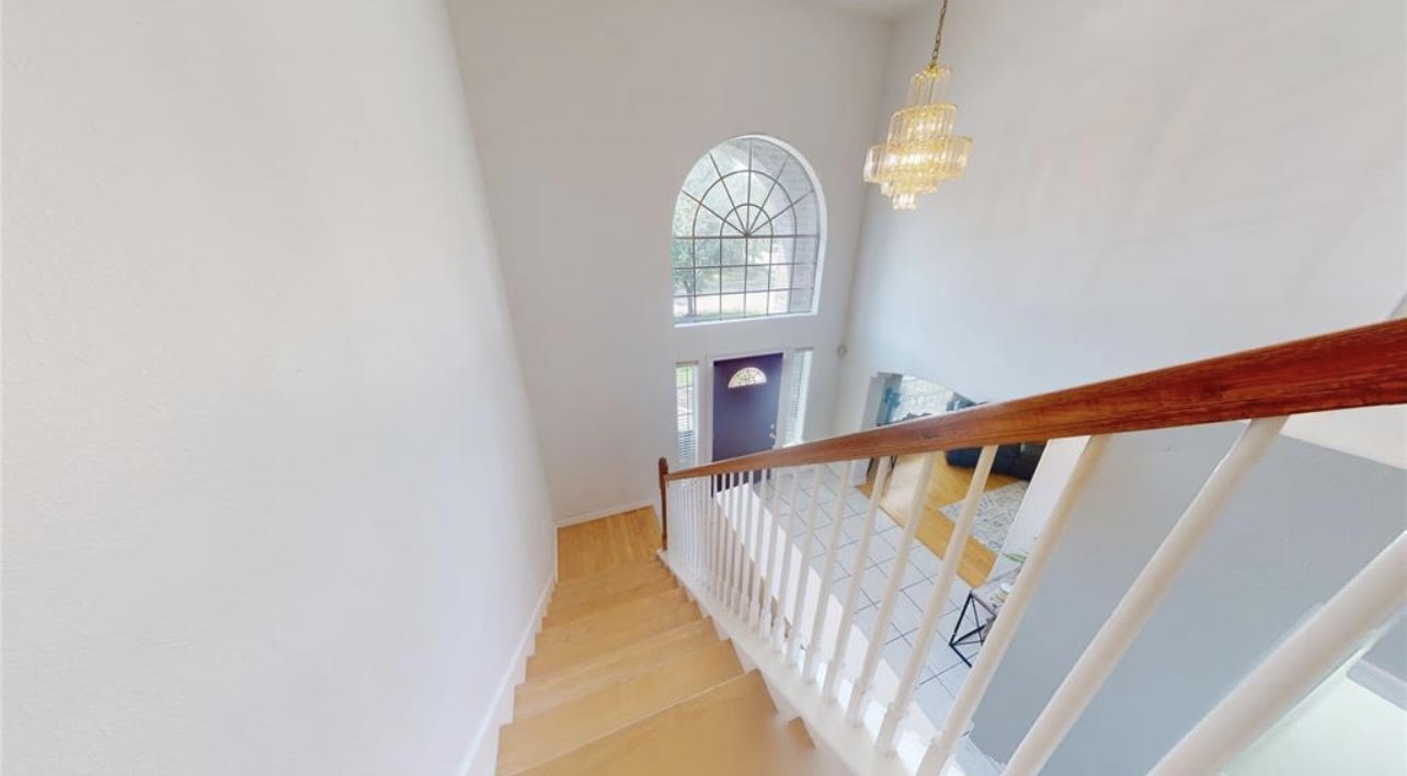 11606 Curry Ridge Lane Tomball, TX 77377 - Photo 12 of 28 The elegant staircase features wooden steps and a classic railing design, creating a stunning focal point in the home’s entryway.