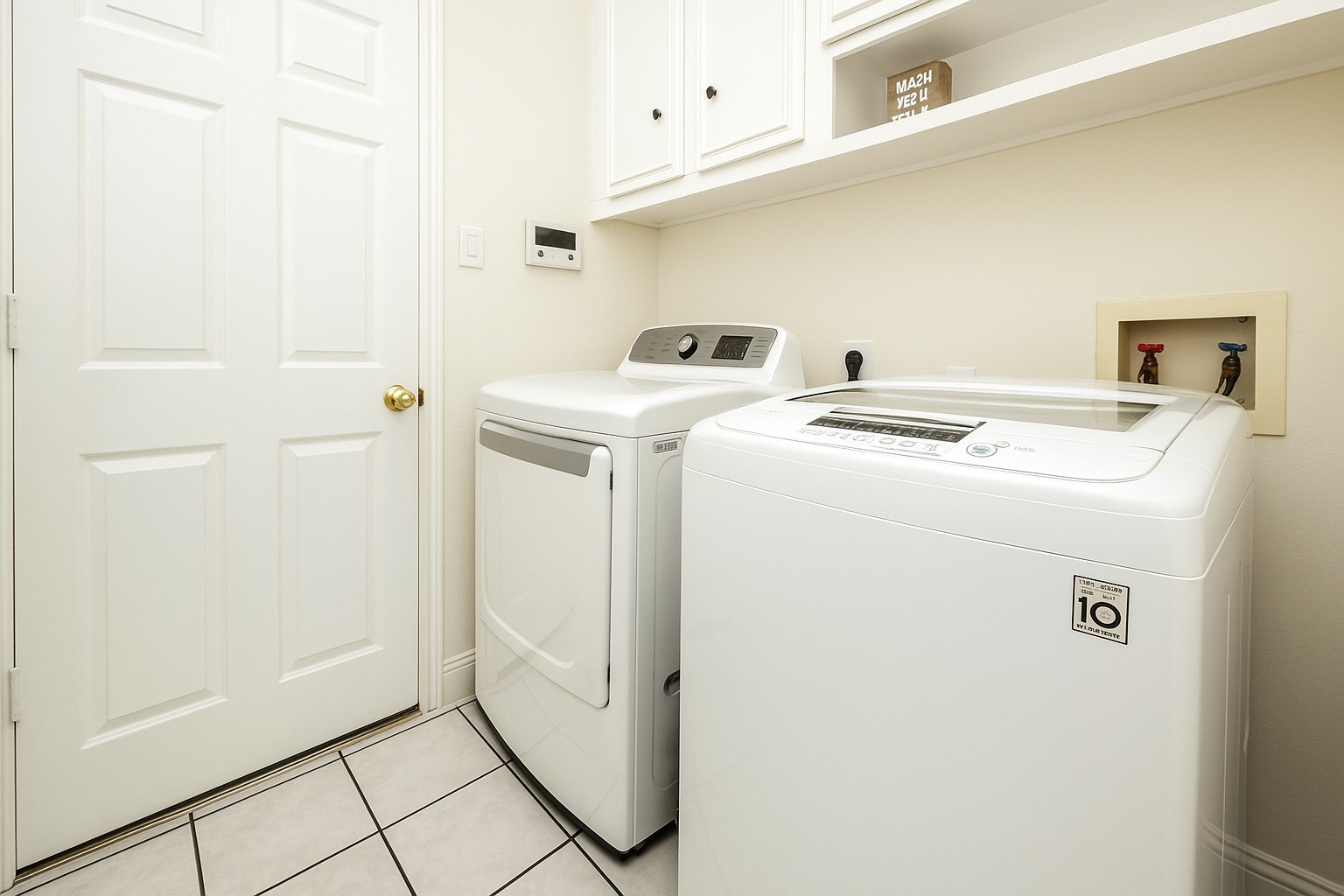 11606 Curry Ridge Lane Tomball, TX 77377 - Photo 26 of 28 The efficient laundry room maximizes space with built-in cabinets and a shelf, providing practical storage and organization in a compact layout.