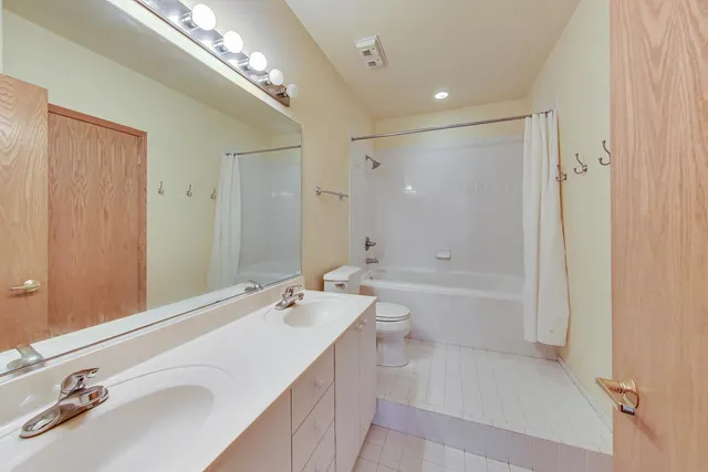 a bathroom with a tub a sink and a large mirror