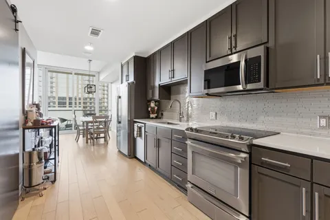 a kitchen with stainless steel appliances a stove sink microwave and cabinets