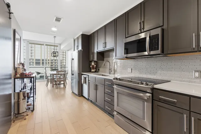 a kitchen with stainless steel appliances a stove sink microwave and cabinets