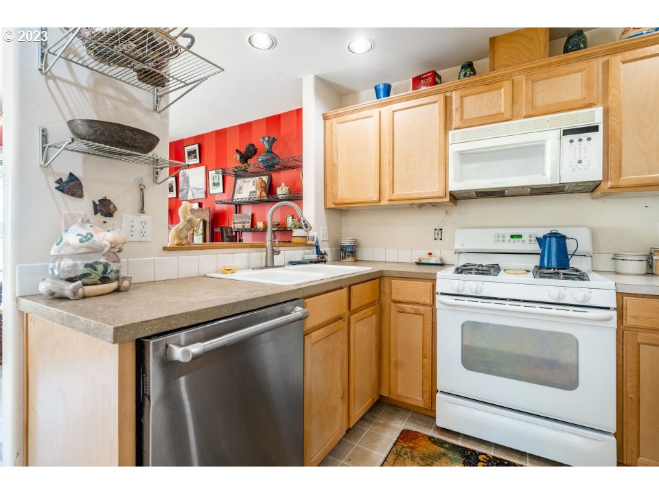 15469 Southwest Bygones Court Beaverton, OR 97007 - Photo 7 of 32 a kitchen with stainless steel appliances granite countertop a sink and cabinets