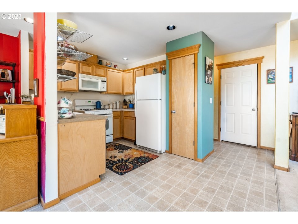 15469 Southwest Bygones Court Beaverton, OR 97007 - Photo 8 of 32 a kitchen with stainless steel appliances granite countertop a refrigerator and a stove