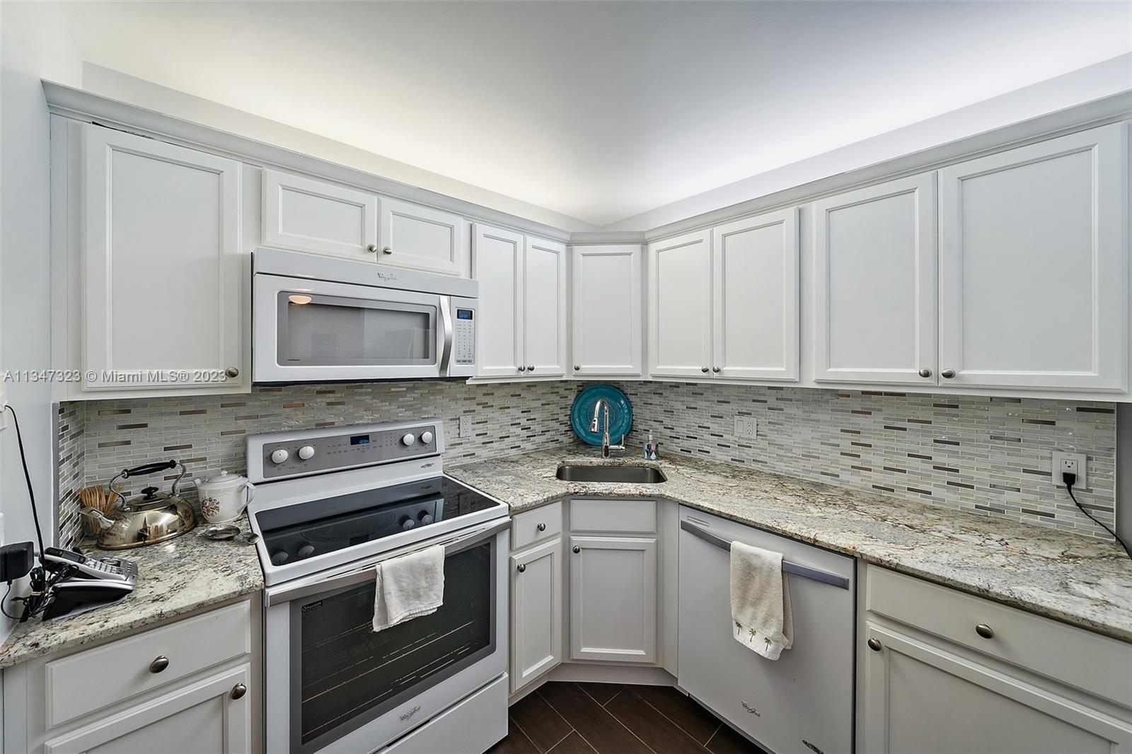 301 Pine Ridge Circle, Unit D2 Greenacres, FL 33463 - Photo 12 of 38 a kitchen with white cabinets stainless steel appliances and sink