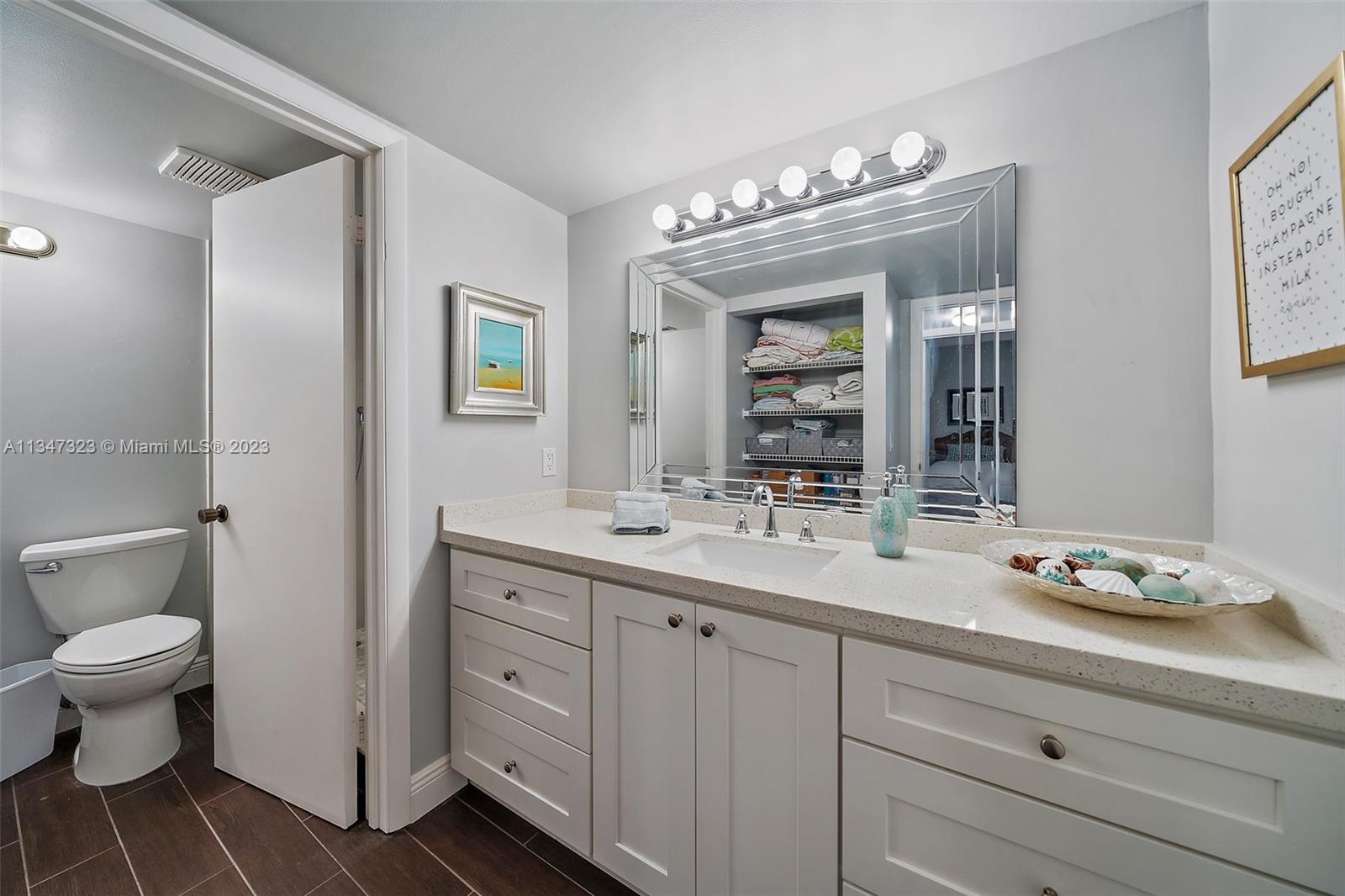 301 Pine Ridge Circle, Unit D2 Greenacres, FL 33463 - Photo 18 of 38 a bathroom with a granite countertop sink a toilet and a mirror