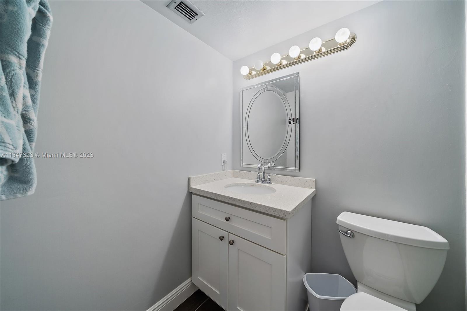 301 Pine Ridge Circle, Unit D2 Greenacres, FL 33463 - Photo 19 of 38 a bathroom with a toilet a sink and mirror