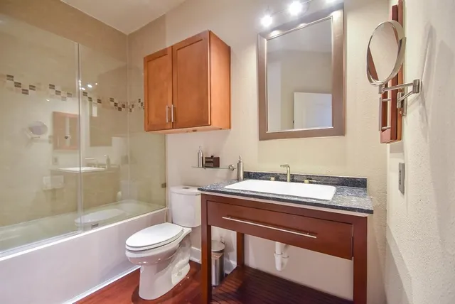 a bathroom with a sink a toilet and shower