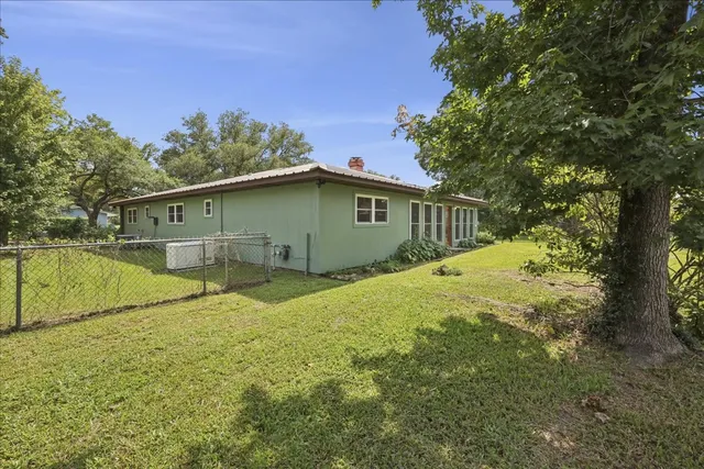 a view of a house with backyard and trees