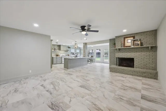 a view of an empty room with a fireplace and a window