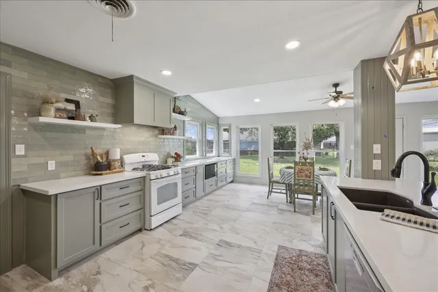 a kitchen with stainless steel appliances granite countertop a sink stove and cabinets