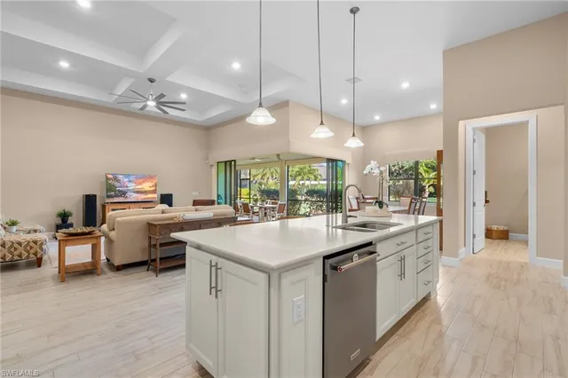 a kitchen with kitchen island a sink and a stove top oven