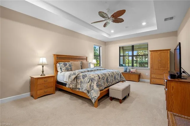 a bedroom with a bed a couch and a chandelier