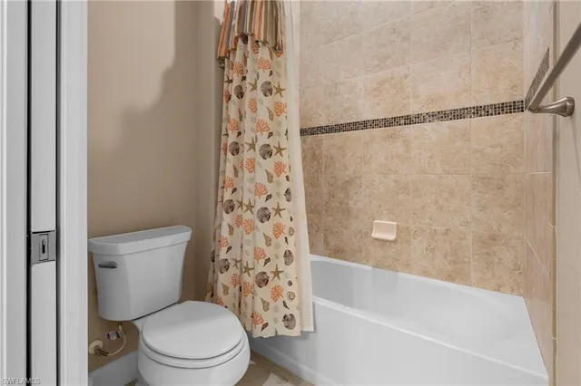 a white toilet sitting next to a bath tub