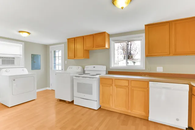 a kitchen with granite countertop a sink cabinets stainless steel appliances and a window