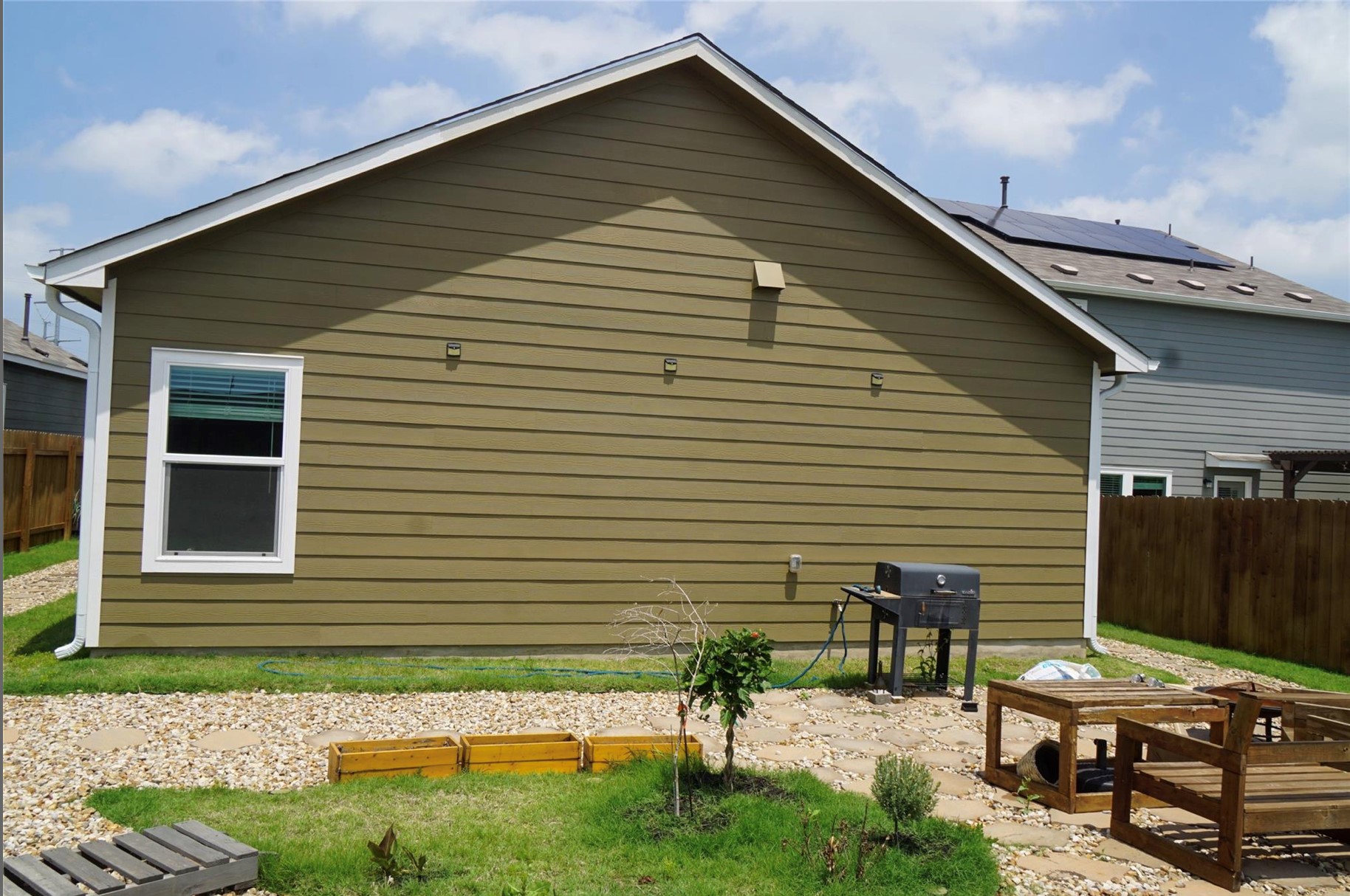 2321 Forgetmenot Lane Manor, TX 78653 - Photo 24 of 27 A quaint backyard with a green lawn and gravel pathway offers an inviting outdoor retreat.