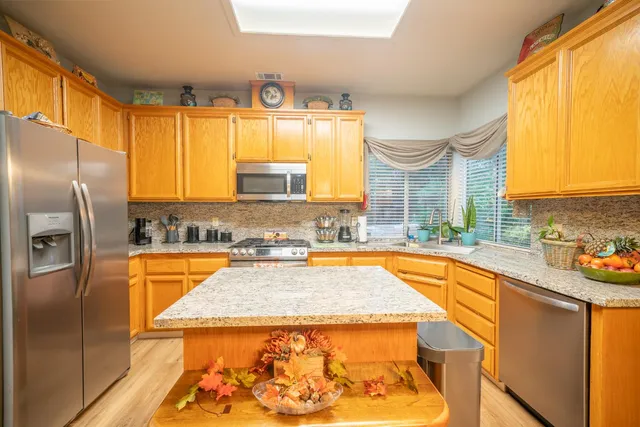 a kitchen with stainless steel appliances granite countertop a sink stove and refrigerator