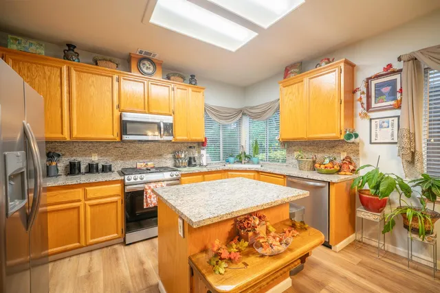 a kitchen with stainless steel appliances granite countertop sink stove top oven and cabinets