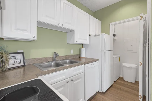 a kitchen with a sink a refrigerator and cabinets