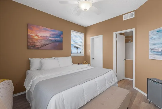 a bedroom with a bed and a painting on the wall