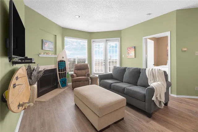 a living room with furniture a flat screen tv and a large window