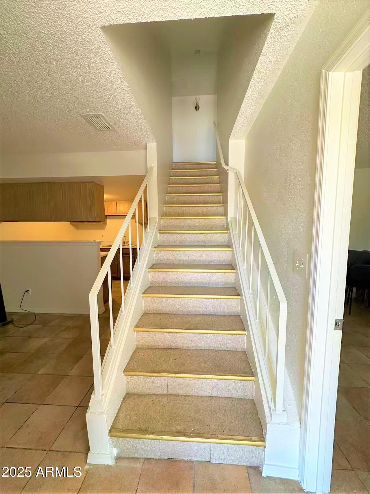 3511 East Baseline Road, Unit 1049 Phoenix, AZ 85042 - Photo 5 of 10 a view of staircase with lots of frames on wall and a rug