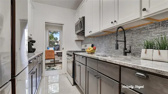 a kitchen with stainless steel appliances granite countertop a sink stove and cabinets