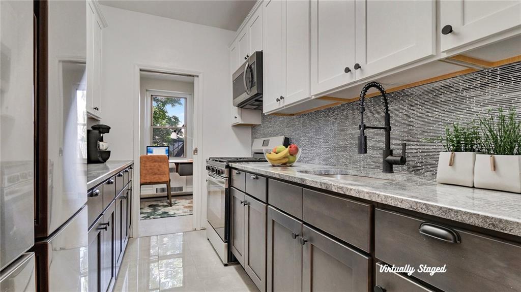 a kitchen with stainless steel appliances granite countertop a sink stove and cabinets