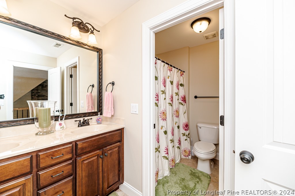 78 Spring Pond Lane Spring Lake, NC 28390 - Photo 29 of 46 a bathroom with a sink a toilet a shower and a mirror