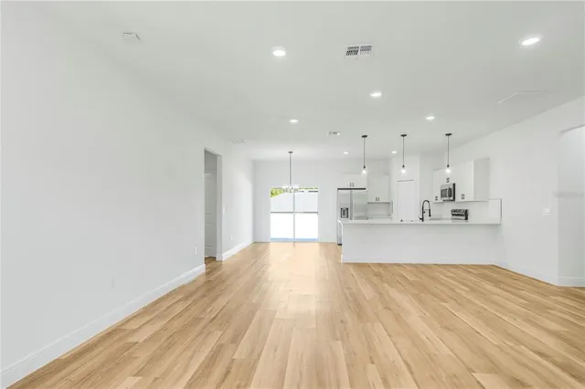 a view of kitchen with kitchen island sink and living room
