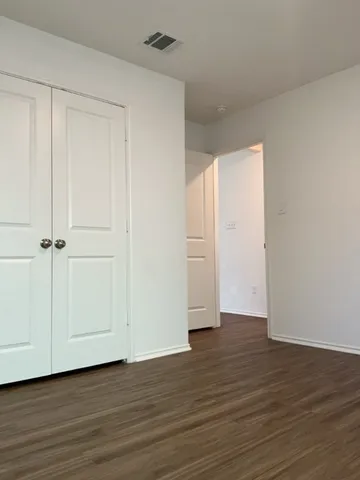 a view of an empty room and wooden floor