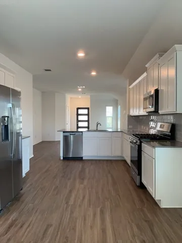 a kitchen with stainless steel appliances a refrigerator and a stove top oven