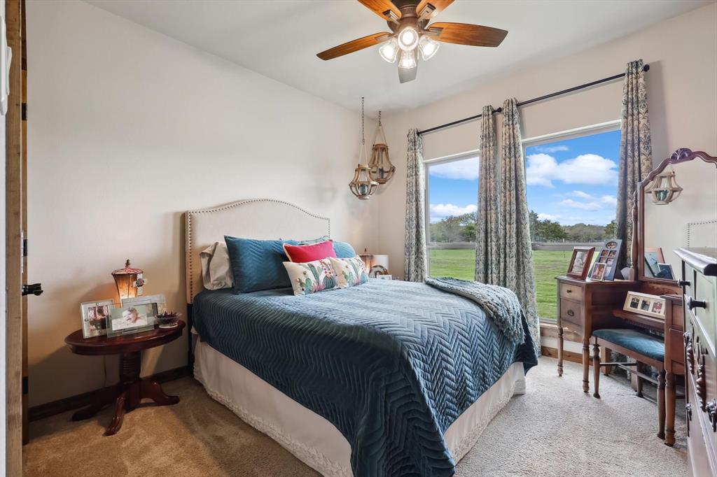 812 McKenzie Road Collinsville, TX 76233 - Photo 18 of 40 a bedroom with a bed and a chandelier
