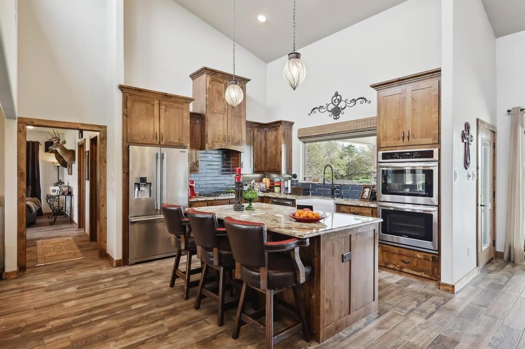 812 McKenzie Road Collinsville, TX 76233 - Photo 6 of 40 a open dining room with stainless steel appliances kitchen island granite countertop a dining table chairs and a refrigerator
