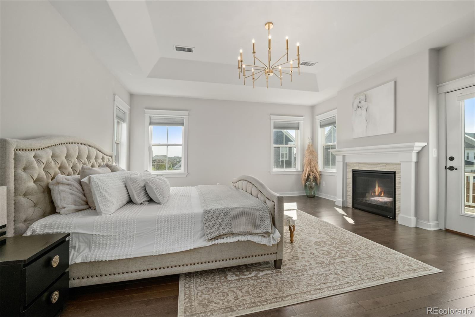 6003 Chester Way Denver, CO 80238 - Photo 18 of 43 a spacious bedroom with a bed and a fireplace