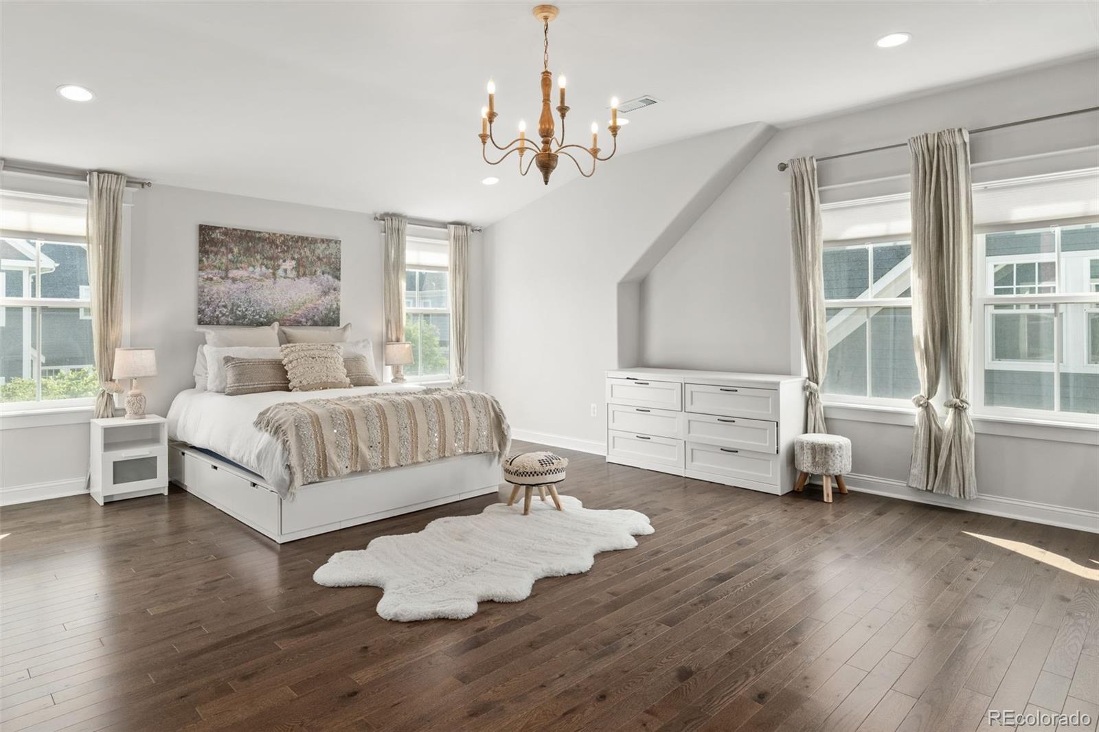 6003 Chester Way Denver, CO 80238 - Photo 22 of 43 a bedroom with a large bed a chandelier and windows