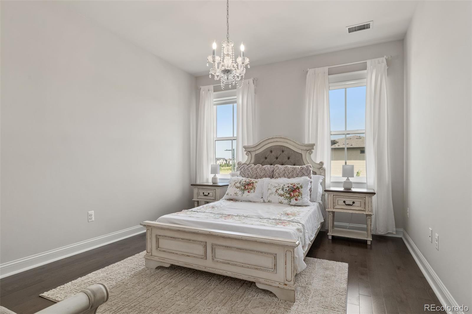 6003 Chester Way Denver, CO 80238 - Photo 24 of 43 a bedroom with a bed and a chandelier