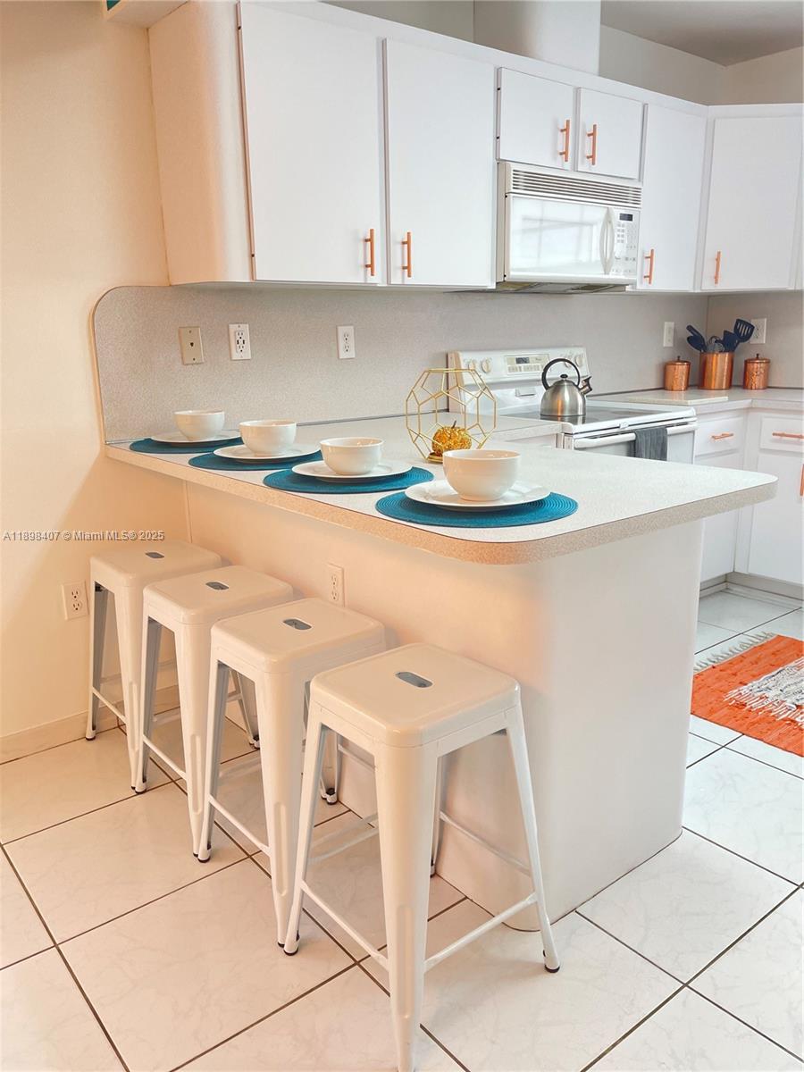 4521 Northwest 4th Street, Unit 4521 Miami, FL 33126 - Photo 5 of 11 a kitchen with a stove a sink and cabinets
