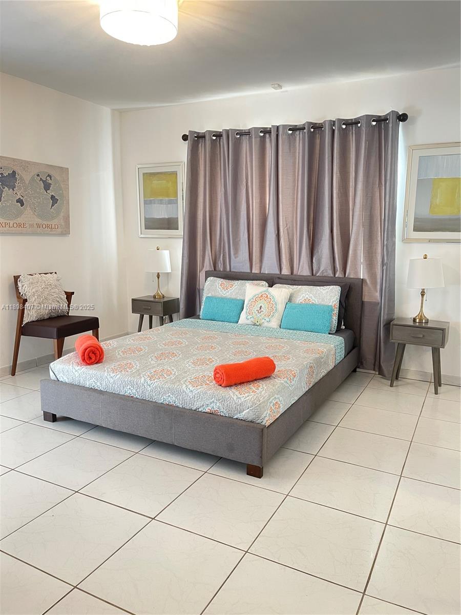 4521 Northwest 4th Street, Unit 4521 Miami, FL 33126 - Photo 6 of 11 a bedroom with a bed and a table in it
