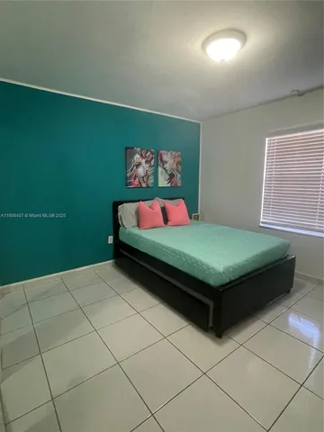 a bedroom with a bed and a wall painting
