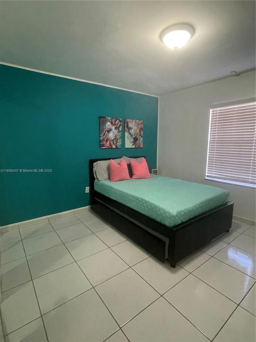 4521 Northwest 4th Street, Unit 4521 Miami, FL 33126 - Photo 8 of 11 a bedroom with a bed and a wall painting