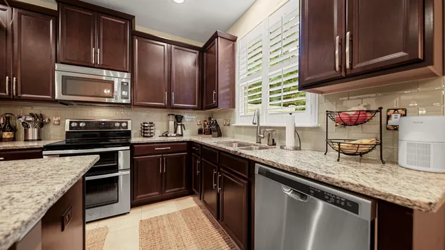 a kitchen with stainless steel appliances granite countertop a sink stove microwave and cabinets