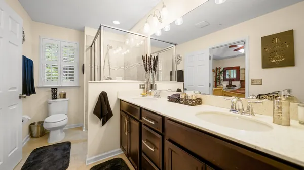 a bathroom with a sink a toilet a mirror and shower