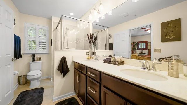 a bathroom with a sink a toilet a mirror and shower