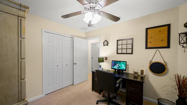 a view of a workspace with furniture and a ceiling fan