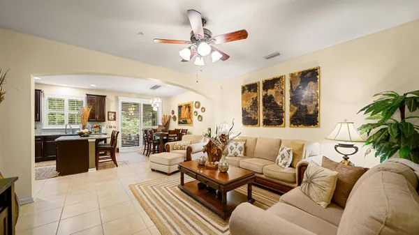 a living room with furniture a chandelier and a window